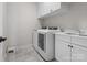 Well-lit laundry room featuring modern washer and dryer, white cabinets, and a sink with chrome fixtures at 120 Trelawn St, Fort Mill, SC 29715