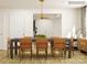 Modern dining room with long dark wood table, tan leather chairs, and entryway view at 13124 Hampton Bay Ln, Charlotte, NC 28262