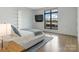 Modern bedroom with a queen bed and large window overlooking a cityscape at 1333 Queens Rd # D4, Charlotte, NC 28207