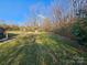 Expansive backyard with lush green grass, mature trees, and a wooden structure providing ample outdoor space at 13655 Broadway Ave, Midland, NC 28107