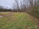 Backyard with overgrown grass and small shed at 13655 Broadway Ave, Midland, NC 28107