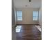 Well-lit bedroom with hardwood floors and two windows at 1638 Hudson Graham Ln, Charlotte, NC 28216