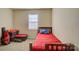 This bedroom has a red bed set, window and ample space for accessories at 1687 Riverdale Dr, Rock Hill, SC 29732