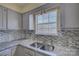 Bright kitchen featuring granite countertops, stainless steel sink and a stylish mosaic tile backsplash at 1687 Riverdale Dr, Rock Hill, SC 29732