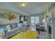 Open living room with a grey sofa and yellow rug that complements the natural light at 1687 Riverdale Dr, Rock Hill, SC 29732