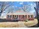 Charming brick ranch house with red door and inviting front porch at 2203 O'Hara Dr, Charlotte, NC 28273