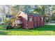 Red wooden storage shed with double doors and side windows at 241 Pinecrest Ct, Taylorsville, NC 28681