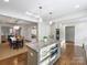 Open kitchen with island, hardwood floors, and views into the dining area at 2625 Croydon Rd, Charlotte, NC 28209