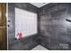 Shower stall with gray tile and a glass block window at 31934 Ameron Cir, Albemarle, NC 28001