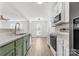 Updated kitchen featuring white cabinets, stainless steel appliances, and a green accent island at 3220 Capitol Dr, Charlotte, NC 28208