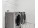 Convenient laundry room with washer and dryer and overhead shelving at 3220 Capitol Dr, Charlotte, NC 28208