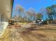 Landscaped backyard with rock pathway, mini excavator, and mature trees at 3720 Fairlane Dr, Gastonia, NC 28056