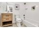 Bathroom with wooden vanity, tub and shower combo, white subway tile, and neutral flooring at 3828 Chandworth Rd, Charlotte, NC 28210