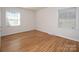 Bright bedroom with hardwood floors, two windows, and neutral walls at 3828 Chandworth Rd, Charlotte, NC 28210