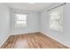 This bedroom features hardwood floors, pale blue walls, and has two large windows for plenty of natural light at 3828 Chandworth Rd, Charlotte, NC 28210
