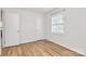 Bright bedroom featuring hardwood floors, a window, and a double door closet for storage space at 3828 Chandworth Rd, Charlotte, NC 28210