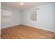 This bedroom features hardwood floors, neutral walls, and two large windows at 3828 Chandworth Rd, Charlotte, NC 28210