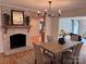 Bright dining room with a brick fireplace, hardwood floors, modern chandelier, and plenty of space for entertaining at 3828 Chandworth Rd, Charlotte, NC 28210