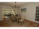 A formal dining room with hardwood floors, elegant lighting, and seating for four provides a space for entertaining at 3828 Chandworth Rd, Charlotte, NC 28210