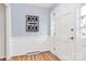 Welcoming entryway featuring a white door, stylish wainscoting, and hardwood floors at 3828 Chandworth Rd, Charlotte, NC 28210