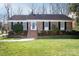 Charming brick home with manicured lawn, black shutters and inviting front porch at 3828 Chandworth Rd, Charlotte, NC 28210