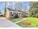 Well-maintained brick home with manicured landscaping, a cozy entrance, and mature trees at 3828 Chandworth Rd, Charlotte, NC 28210
