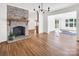 Inviting living room featuring hardwood floors, a brick fireplace, and an open layout at 3828 Chandworth Rd, Charlotte, NC 28210