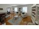 Cozy living room with a piano, white armchairs, a bookshelf, and a round coffee table at 3828 Chandworth Rd, Charlotte, NC 28210