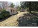 Outbuilding featuring double doors and a neutral exterior, surrounded by lush landscaping at 3828 Chandworth Rd, Charlotte, NC 28210