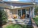 Inviting outdoor patio with sliding glass doors, seating, and charming landscaping at 3828 Chandworth Rd, Charlotte, NC 28210