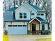 Two-story white farmhouse-style home with a gray roof and a brick base at 604 N Providence St, Waxhaw, NC 28173