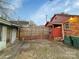 View of fenced backyard including storage shed, gravel area, and parking space at 630 N Moran St, Gastonia, NC 28052