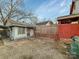 View of fenced backyard including storage shed, gravel area, and parking space at 630 N Moran St, Gastonia, NC 28052