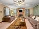 Comfortable living room featuring a brick fireplace, ceiling fan and neutral tones at 630 N Moran St, Gastonia, NC 28052