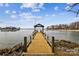 Community boat dock with wooden walkway leading to covered pier at 7513 Mariner Cove Dr, Cornelius, NC 28031