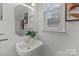 Small bathroom with pedestal sink and framed art at 7620 Rolling Meadows Ln, Huntersville, NC 28078