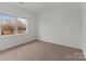 Bright bedroom with carpeted floor, window, and double door closet at 7620 Rolling Meadows Ln, Huntersville, NC 28078