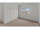 Spacious bedroom with carpeted floor, window, and double door closet at 7620 Rolling Meadows Ln, Huntersville, NC 28078