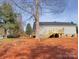 Exterior view showcasing the home's gray siding, back deck, and spacious, unfinished backyard at 823 Wellwood Ave, Statesville, NC 28677