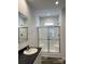 Modern bathroom featuring a walk-in shower with glass doors, a sink, and great lighting at 823 Wellwood Ave, Statesville, NC 28677