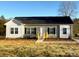 Charming home featuring gray siding, black shutters, complemented by a welcoming wooden porch and fresh landscaping at 823 Wellwood Ave, Statesville, NC 28677