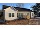 Charming home featuring gray siding, black shutters, complemented by a welcoming wooden porch and fresh landscaping at 823 Wellwood Ave, Statesville, NC 28677