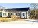 Charming home featuring gray siding, black shutters, complemented by a welcoming wooden porch and long drive way at 823 Wellwood Ave, Statesville, NC 28677