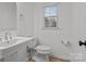 Simple bathroom with white sink, toilet, and light wood floors at 841 Deerfield Dr, Mount Holly, NC 28120