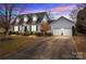 Two-story house with gray siding, two-car garage, and landscaping at 841 Deerfield Dr, Mount Holly, NC 28120