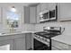 Modern kitchen with stainless steel appliances and gray cabinets at 841 Deerfield Dr, Mount Holly, NC 28120