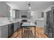 Modern kitchen with gray cabinets, marble island, stainless steel appliances, and hardwood floors at 841 Deerfield Dr, Mount Holly, NC 28120