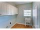 Laundry room with white cabinets and a utility sink at 8622 Lower Rocky River Rd, Concord, NC 28025