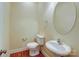 Powder room with toilet, sink, and oval mirror at 8622 Lower Rocky River Rd, Concord, NC 28025