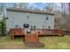 Exterior view of back of home, with wooden deck and stairs to yard at 9230 Windygap Rd, Charlotte, NC 28278